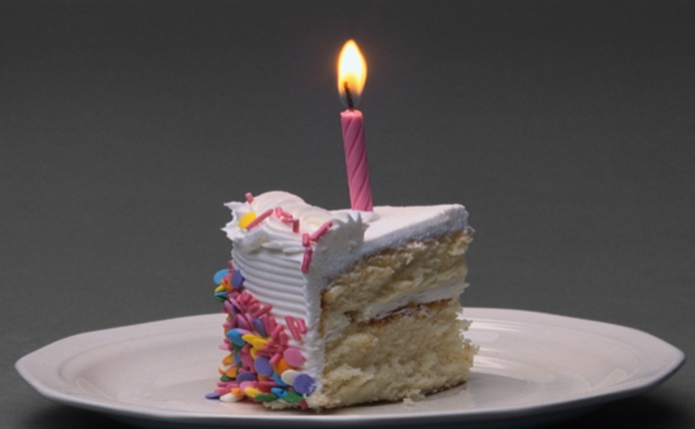 slice of birthday cake with candle on top